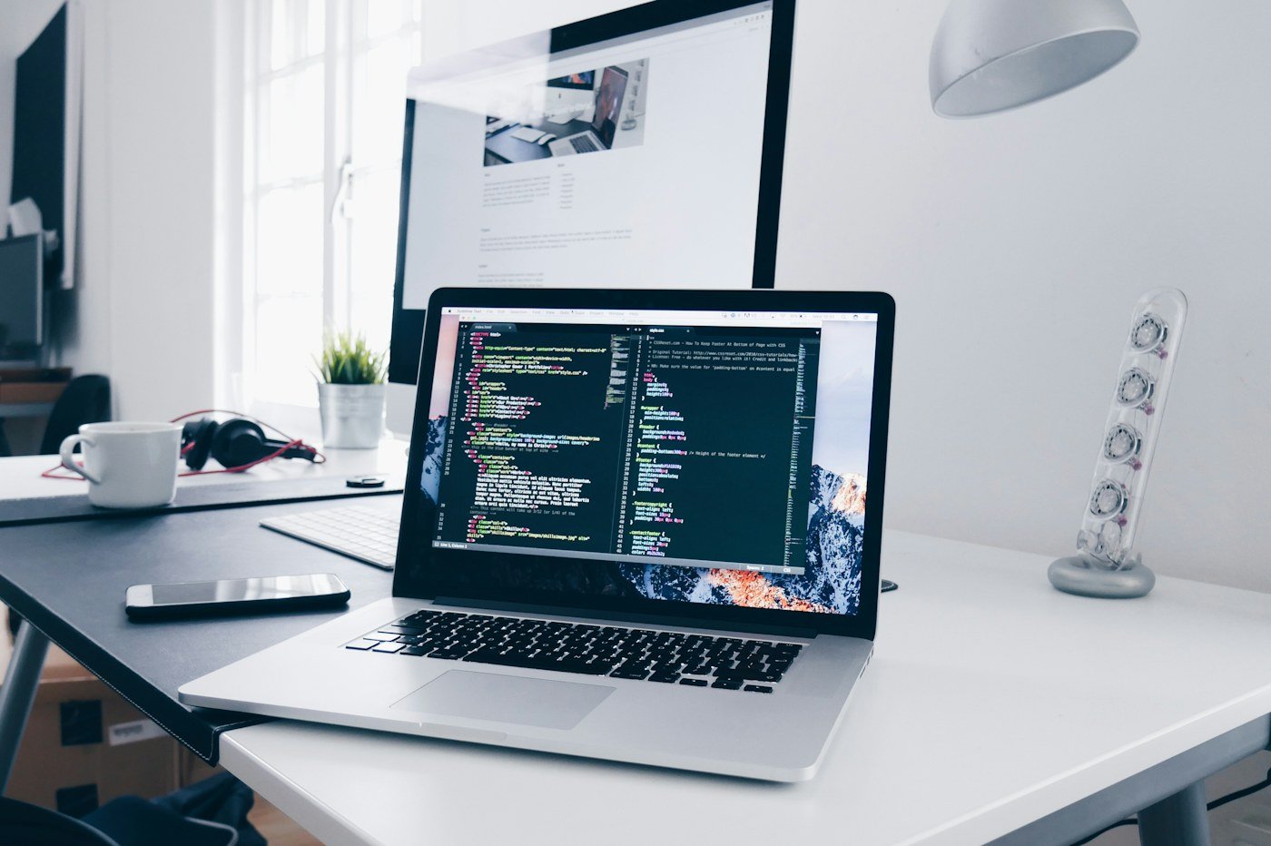 Laptop showing website development work on a desk